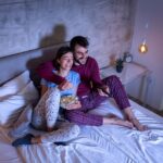 Couple watching TV in bed