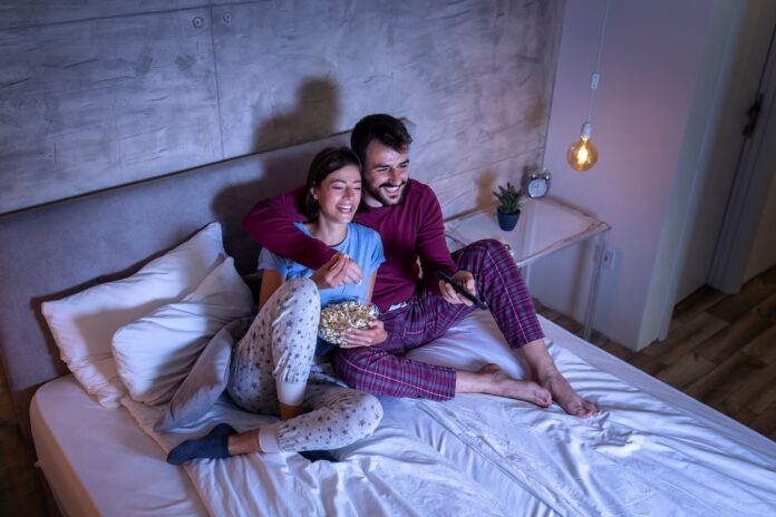 Couple watching TV in bed Couple watching TV in bed